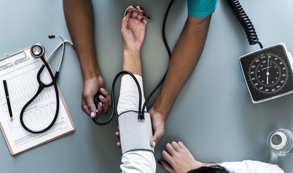 Healthcare provider administering blood pressure test.