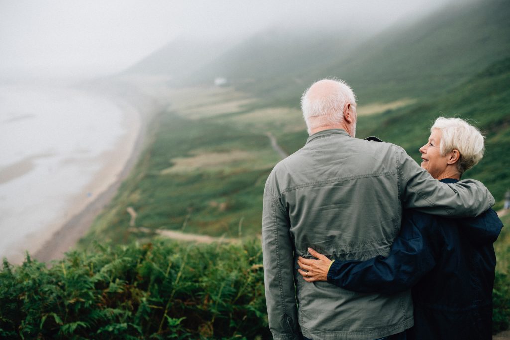 Senior couple at the pot of a hill overlooking a landscape