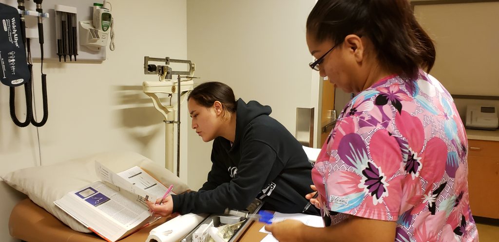 Two medical assisting students reviewing wound care