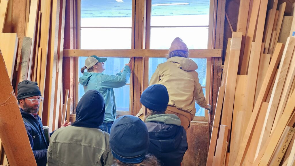 Students work on taking out windows during a Window Restoration workshop in the Historic Preservation and Restoration program
