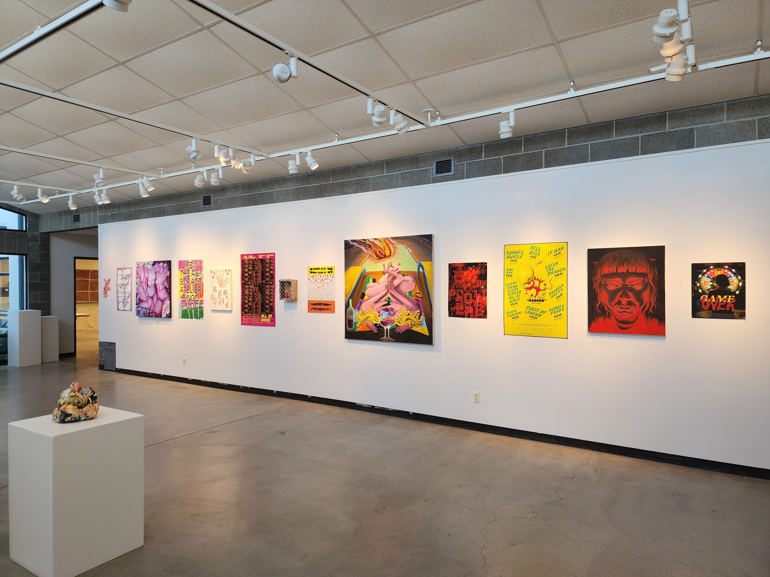 Photo of wall in art gallery with a row of artwork hanging on it