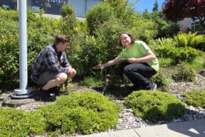 Matt Solberg and Flint Largin pose by the plants in the pollinator garden