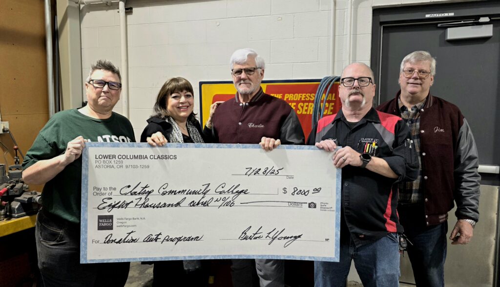 a large check is held up by college and car club representatives