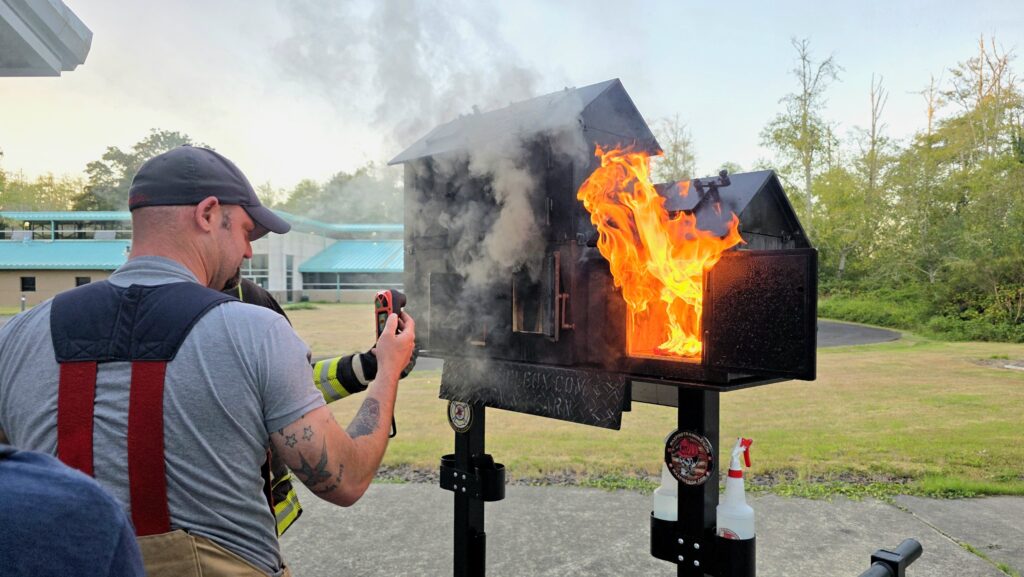 a firefighter studies how fire moves through a model of a structure