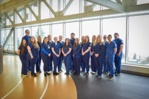 Class of 2026 Nursing Program Students standing in two rows dressed in scrubs