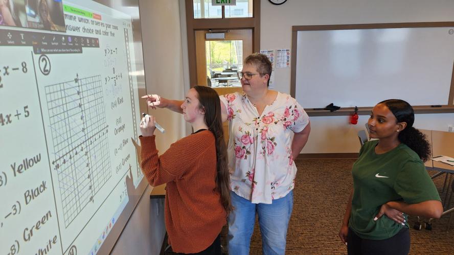 Math Instructor Celeste Petersen works with a student at the smart board in class
