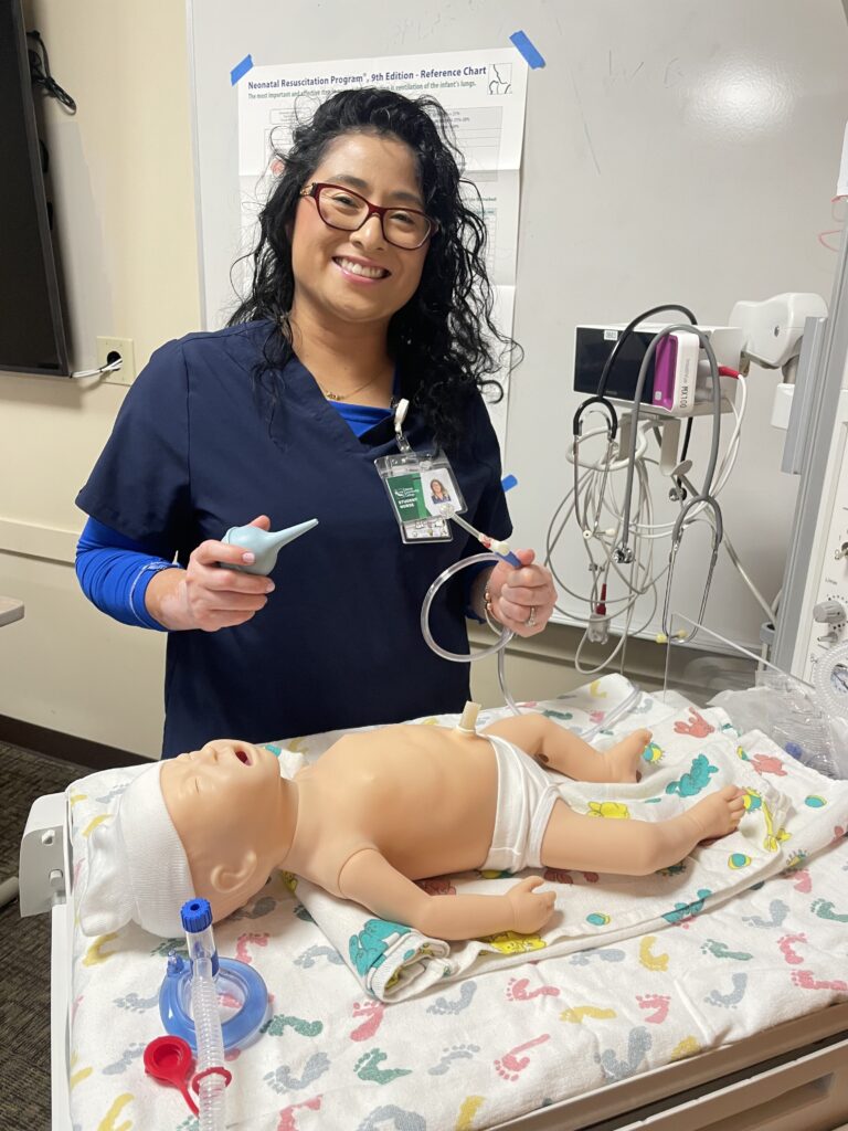 Argie Mendez-Alvarez in nursing class with a baby mannequin 