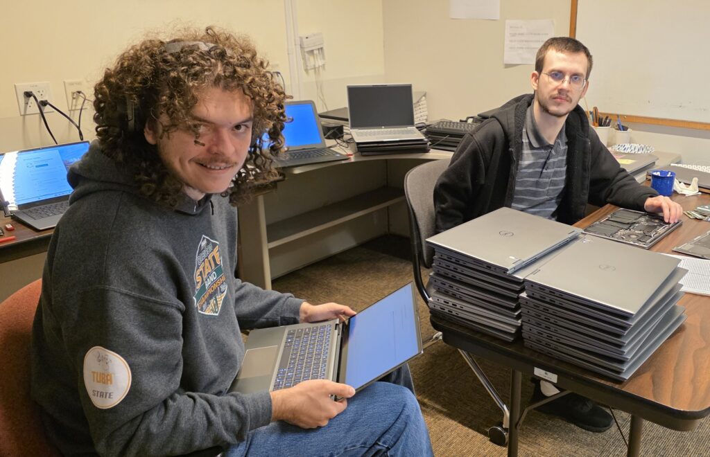 CCC Computer Services work-study students work on the donated laptops