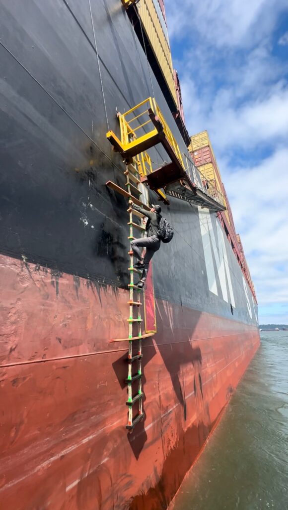 Kyle climbing a ladder on the side of a ship