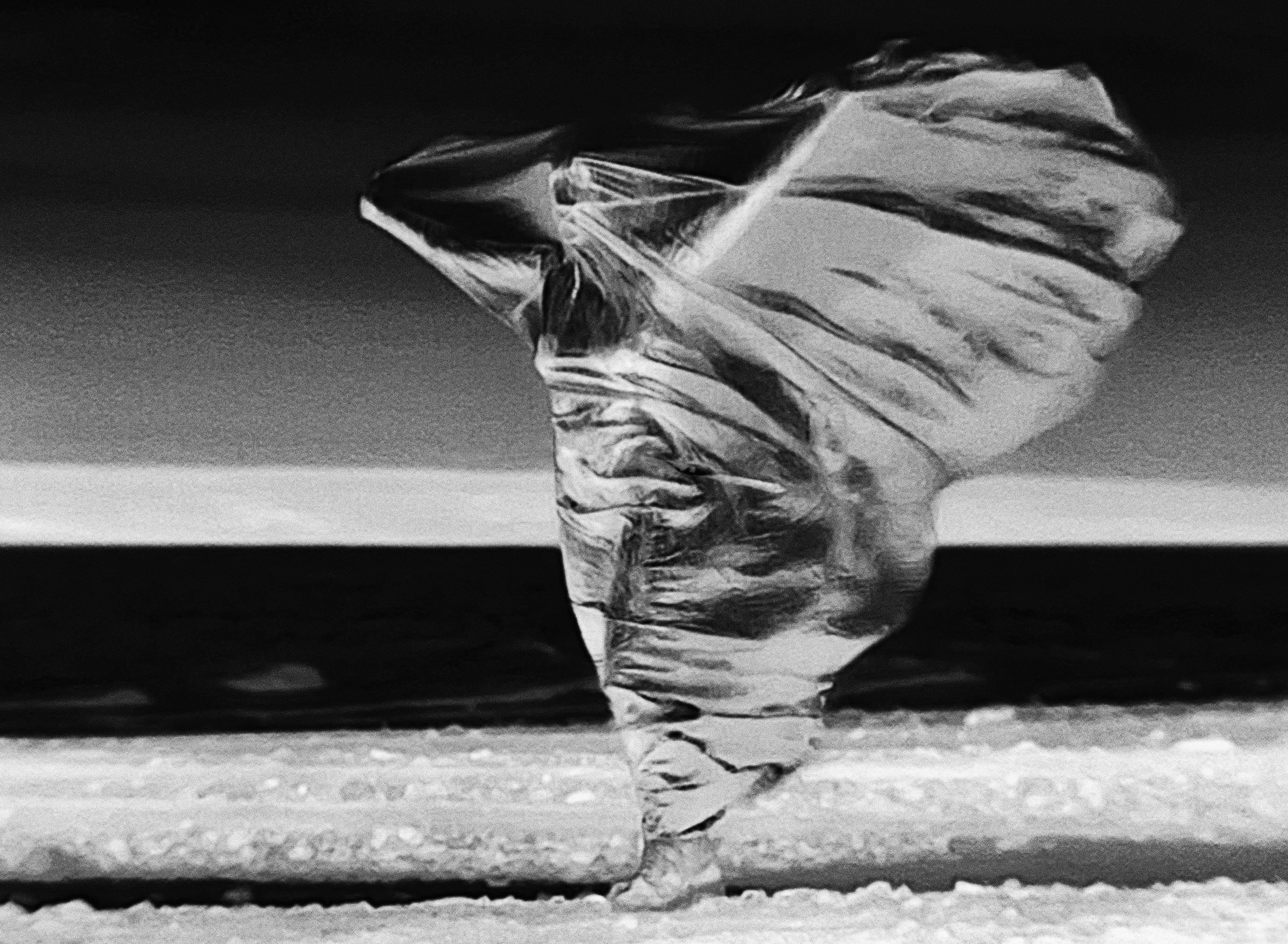 An infrared thermal video still as a digital photograph, depicting a woman' body beneath metallic fabric with their heat signatures visible.