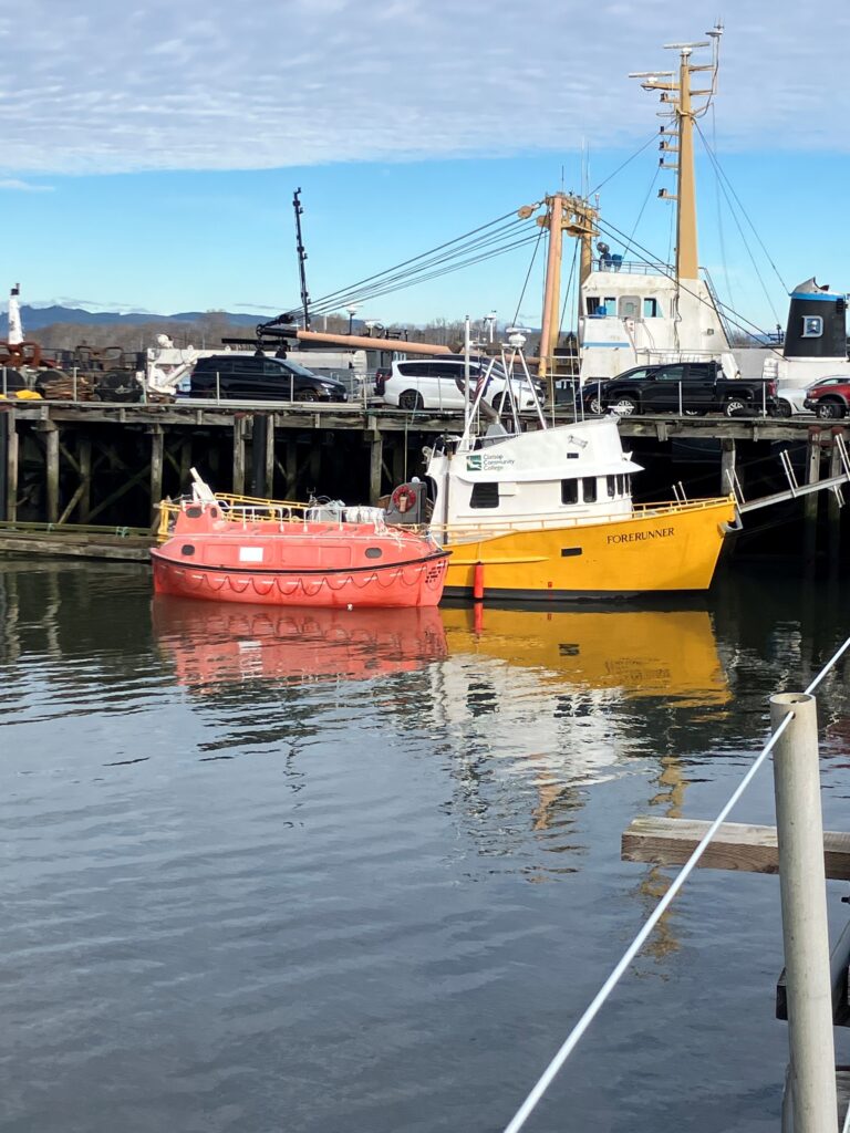 Motor lifeboat docked next to the M/V Forerunner vessel in the Maritime Science department