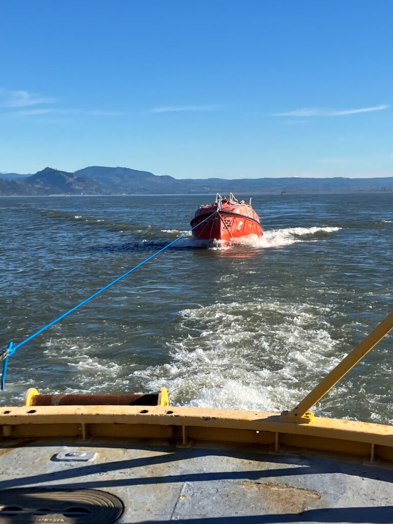 Motor lifeboat being pulled by the Maritime Science department vessel, the M/V Forerunner