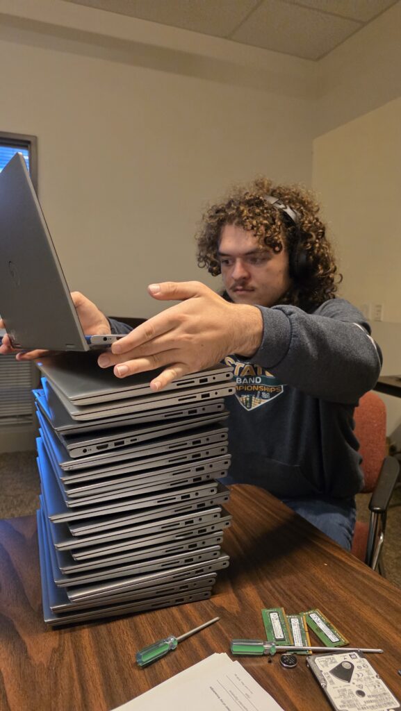 Work-study student Nicholas inventories the donated laptops