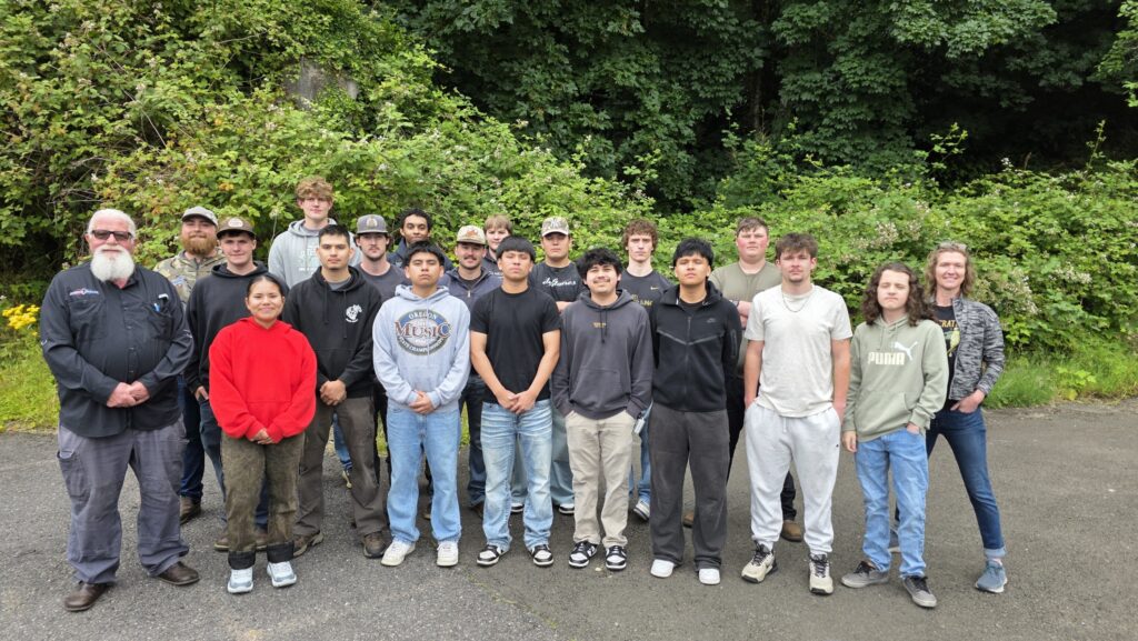 Group of students standing in rows with the two instructors flanking them at the ends.
