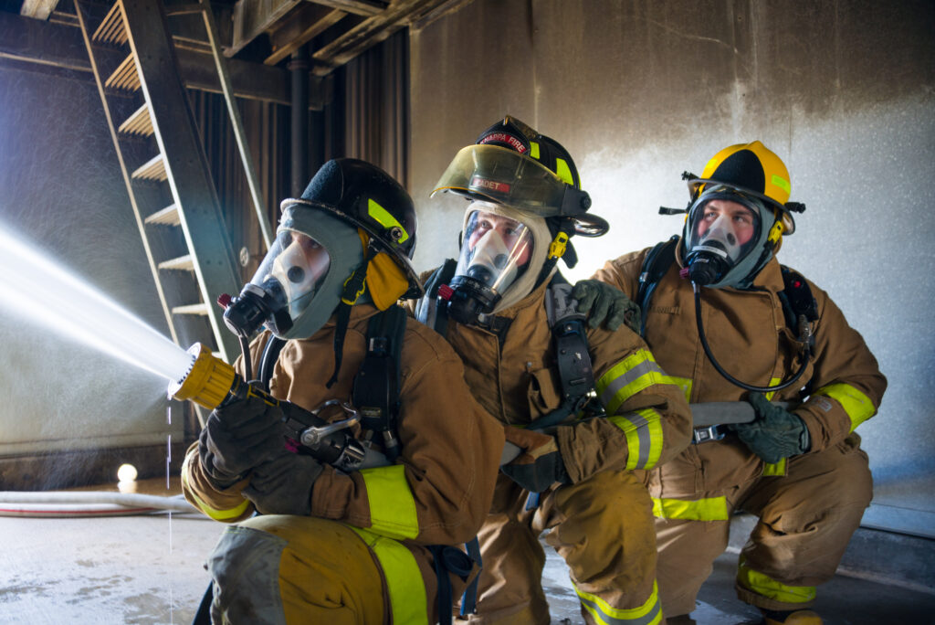 fire science students using air tank system while doing hands on training