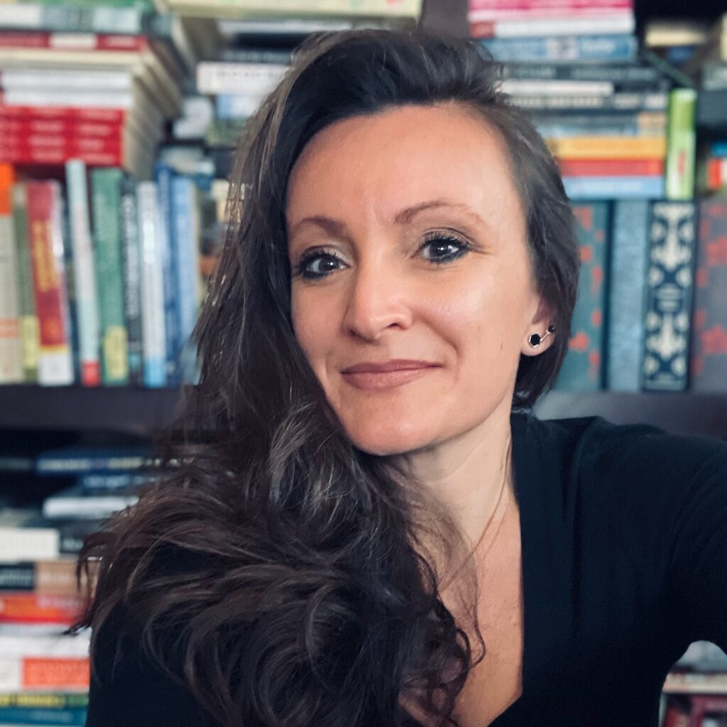 instructor in front of books on shelf