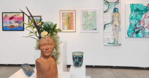 statue and art displayed on wall in gallery